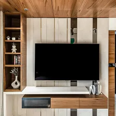 A contemporary TV unit that combines open shelving for decor with closed cabinets for media devices. The mix of wood and white finishes creates a balanced and modern look.