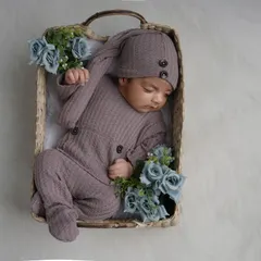 Using simple, natural props like this woven basket helps to highlight the smallness and innocence of your newborn. This little one is sleeping soundly in a cozy, buttoned outfit.