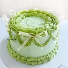 A pastel whisper of sweetness. This vintage-style cake in a lovely shade of green features intricate buttercream piping and delicate ribbon bows.