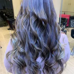 This is a perfect example of a cool-toned balayage with soft, beachy waves. We specialize in creating these custom-blended looks that grow out beautifully and give the hair a natural, sun-kissed dimension.
