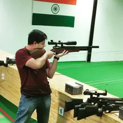 This shooter is using an air rifle equipped with a scope. While not used in 10-meter competitions, it's a fun way to practice precision aiming.