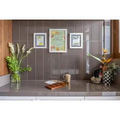 A close-up of the kitchen counter, featuring charming, framed art against a tiled backsplash. We believe in adding personal touches to make every corner of the home feel special.
