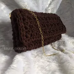 This is the Trinity Rae crochet bag, which I made with thick T-shirt yarn. It's a sturdy and stylish clutch-style bag with a gold chain strap, shown here in a rich chocolate brown.
