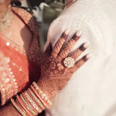 A close-up on the details of love. The bride's hand, adorned with henna and her wedding ring, rests gently on her groom's chest. It’s a simple shot that tells a story of commitment and togetherness.