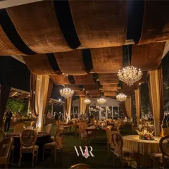 Inspired by the warmth of barn weddings, we designed this dining space with rich brown velvet ceiling drapes and rustic wooden tables. The glow of the chandeliers added a touch of luxury, creating a cozy atmosphere for a winter wedding.