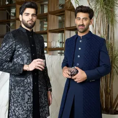 Two examples of evening elegance. On the left, a black kurta with a subtle, shimmering pattern, and on the right, a navy blue layered Indo-Western set with a textured jacket.