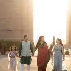 A family of four walks hand-in-hand against the iconic backdrop of India Gate at sunset. Outdoor shoots allow us to create stunning, cinematic portraits.