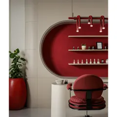 This is the manicure and pedicure station, designed as a focal point. The circular niche, finished in a rich red fabric, creates a cozy and private feel, while the custom overhead lighting provides perfect illumination for detailed work.