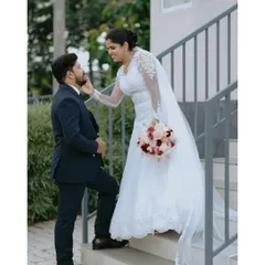 A tender moment on the stairs, showcasing the beautiful lace details of the bride's gown and the connection between the couple.