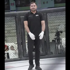 A portrait of our coach in his official VFC referee uniform, ready for action inside the cage.