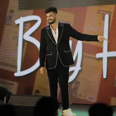 A client owning the stage in our custom black suit with distinctive white piping detail. This is how we tailor a classic black suit to reflect a client's unique personality and flair.