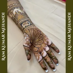 Another angle of the peacock feather mehandi, highlighting the beautiful floral patterns on the fingers and the detailed work on the arm.