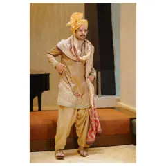 The groom looking sharp and ready for the big day. This portrait showcases his complete outfit, from the detailed kurta and salwar to the stylishly draped shawl.