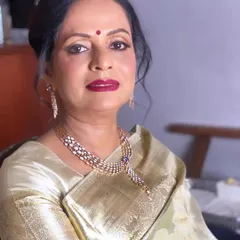 A portrait of the glamorous mother of the groom. Her look features a bold lip and defined eyes, perfect for a wedding reception and making sure the groom's side is represented with style.