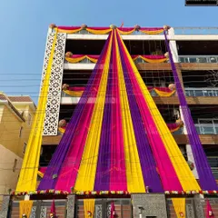 A spectacular display of home decor. I used massive drapes in yellow, pink, and purple to create a tent-like structure covering the entire facade of the building, making it look incredibly grand.