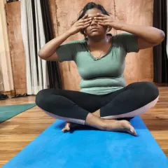 A student finds a moment of peace while practicing Bhramari Pranayama. This simple breathing technique can be done anywhere to instantly quiet the mind and reduce tension.
