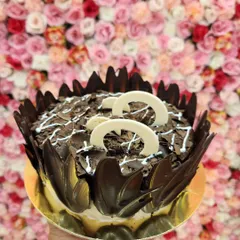 This is my Chocochip Delight cake, loaded with lots of chocolate and love. It's covered in rich chocolate shavings and decorated with white chocolate curls, offering a wonderful mix of textures and chocolatey goodness.
