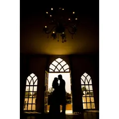 A classic silhouette of the couple framed by ornate windows and a chandelier. This pre-wedding photo has a timeless, grand, and romantic feel.
