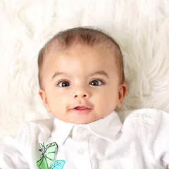 A sweet individual portrait of the second twin from the same six-month session. His bright, curious eyes are the focus of this simple and clean shot.
