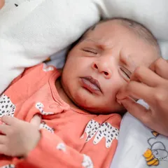 The beautiful, wrinkled expression of a newborn just days old. We love getting close-up shots that capture the tiny details and fleeting faces your baby makes during their naming ceremony.