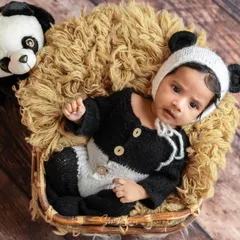 Our tiny panda is wide awake and curious. Dressed in a black and white knitted panda outfit, this little one is ready for his close-up in a cozy basket.