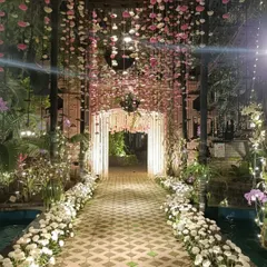 A magical floral entrance to welcome guests. This walkway features a canopy of hanging pink and white flowers, creating a dreamy, starlit path that leads into the heart of the wedding celebration.