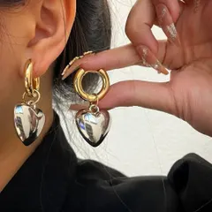 A close-up of the 18k gold plated classic retro heart earrings being worn. They are the perfect blend of modern and playful.