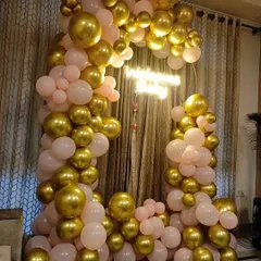 For a classic and elegant look, I offer balloon arches in chrome gold and pastel pink. This setup creates a beautiful photo corner for an engagement party or anniversary celebration, complete with a custom neon sign.