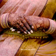 An artistic shot of the deep henna stain, beautifully complementing the bride's traditional saree and jewelry. The color is simply perfect.