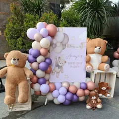 A sweet and cozy teddy bear birthday party entrance. This setup features a personalized welcome sign for Anaya's party, framed by a lovely balloon arrangement and surrounded by adorable teddy bears of all sizes.