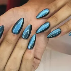 For a bold and mesmerizing look, I use a magnetic cat-eye polish. This set features a stunning blue shade on long almond-shaped nails, creating a deep, shifting shimmer that catches the light from every angle.