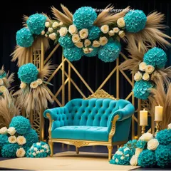This wedding stage combines modern geometry with soft, natural elements. I used a gold-toned geometric frame as the backdrop, adorned with turquoise and cream floral arrangements and dried pampas grass for a unique, contemporary look. The tufted turquoise sofa completes this stylish setup.
