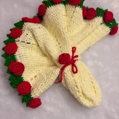 The rose blanket folded into its bouquet shape. The red tie holds it together, making it look like a cone-shaped floral arrangement.