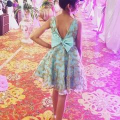 This party frock features a beautiful light blue organza with gold embroidery. My favorite detail is the oversized bow on the open V-back, which adds a touch of playful elegance to this custom party dress.