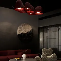 A render for a moody and sophisticated den in a Kolkata home. The design features a deep red sofa, sculptural furniture, and unique, textured ceiling lights to create a cozy yet dramatic atmosphere.