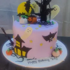 A spooky and fun Halloween-themed cake. This cake is decorated with ghosts, bats, pumpkins, and a haunted house, perfect for a Halloween birthday party.