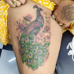 A royal peacock tattoo is a symbol of beauty and pride. I love working with color to create vibrant, timeless masterpieces like this one. We designed this piece to flow perfectly on the thigh, making it a bold and elegant statement.