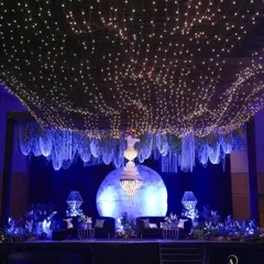 I love creating immersive worlds for evening celebrations. Here, a canopy of starlit fairy lights and hanging floral installations created a celestial dreamscape, with a glowing moon backdrop for a truly magical Sangeet night.
