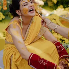 The bride bursts into laughter as a relative playfully applies Haldi during her ceremony at the Sheraton Hua Hin, Thailand.