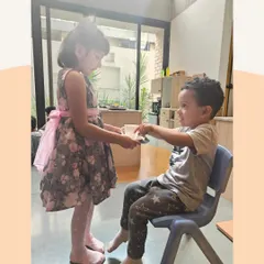 This interaction teaches children how to offer and receive things politely. These daily practices in grace and courtesy build a foundation of mutual respect.