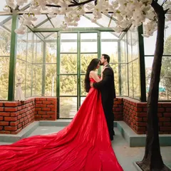 This stunning red trail gown creates a dramatic effect with its expansive fabric. It's a perfect choice for creating memorable, high-impact images in any setting.