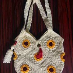 My granny square tote bag, featuring a cheerful sunflower pattern and decorative tassels, is a perfect blend of bohemian style and practical design for everyday use.