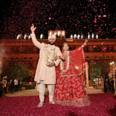 A royal destination wedding in Jaipur, complete with a flower petal shower against the palace backdrop. We handle all the logistics of destination weddings to create a seamless and majestic experience.