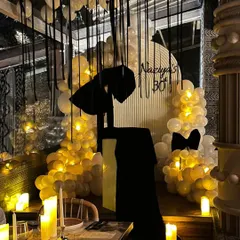 For this chic 30th birthday, we designed a "Bow-tiful" theme with a moody black and white palette. The decor features dramatic black bows, warm candle lighting, and elegant balloon arrangements for a sophisticated and modern milestone party.