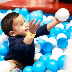 Gentle fun for our littlest visitors. A toddler enjoys the soft and safe environment of our My Burrow ball pit, designed specifically for ages 2 to 4. This area is perfect for sensory play and developing motor skills.