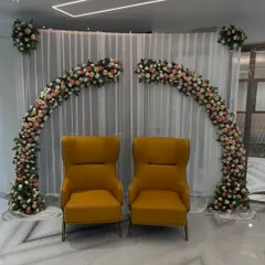 A simple yet beautiful backdrop for a ring ceremony at home. Two floral half-arches frame the couple's seating, creating an elegant photo corner.