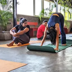 A student gets some encouragement from a furry friend. Puppy yoga is a reminder not to take ourselves too seriously and to find joy in the present moment.