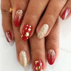 Perfect for celebrations, this festive manicure combines a rich red base with accent nails in full-coverage gold glitter and delicate gold foil flakes. This is a popular choice for bridal parties and holiday events.