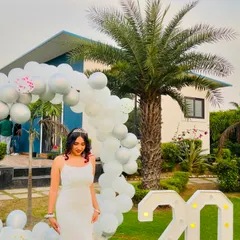 Posing with my "20" marquee lights and birthday decorations. This shot captures the festive atmosphere of my party.