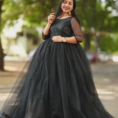 A classic black ball gown made of soft tulle with sheer, dotted sleeves. This is a timelessly elegant choice for an evening photoshoot, offering a sophisticated and dramatic look.